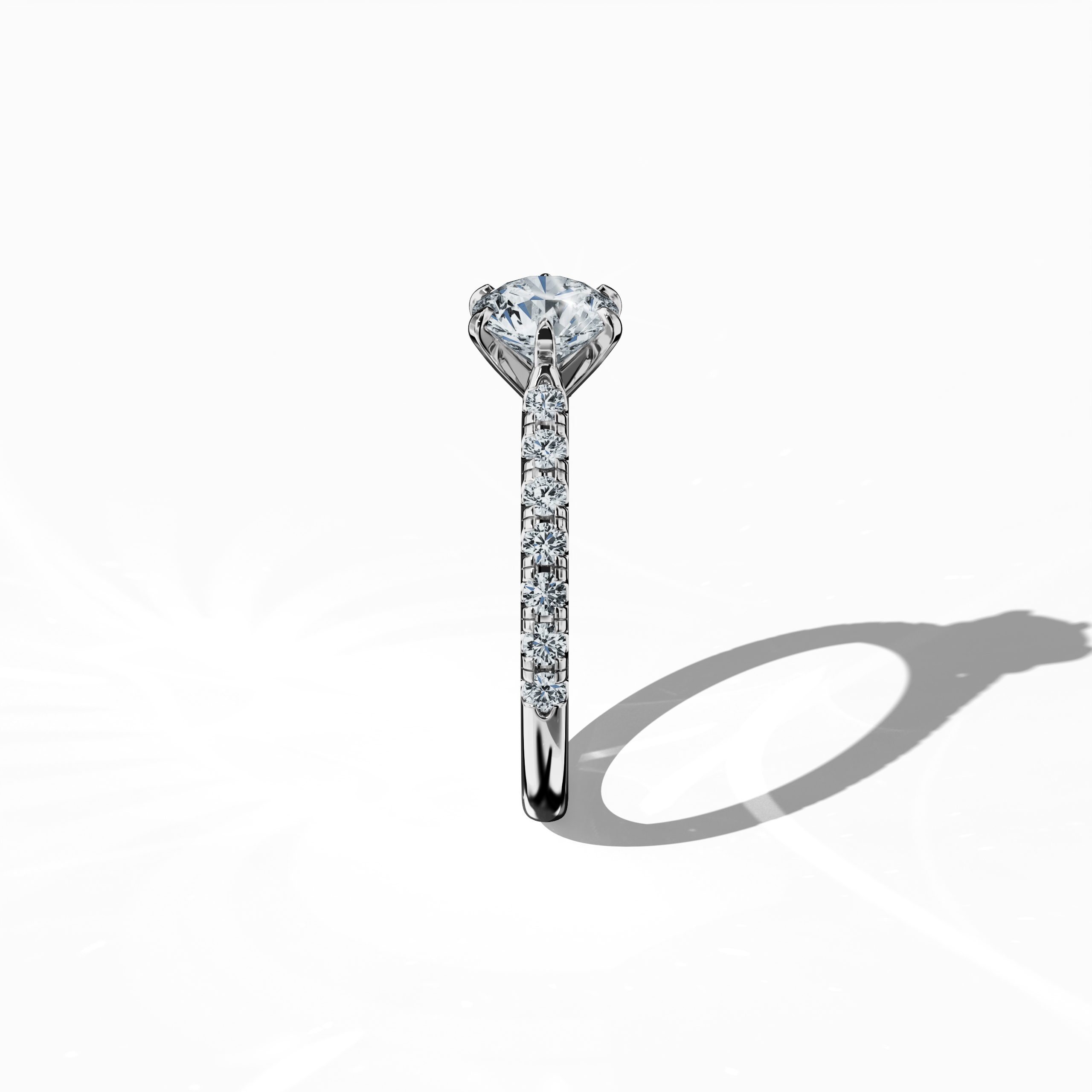 Side view of a белое золото solitaire paved ring, highlighting a brilliant 1 карат center/centre diamond and 0.21 карат side diamonds along a slim band set in a refined four nail prong design. This perspective accentuates the ring’s elegant profile and minimalist design, making it an exquisite engagement ring, wedding band, or fine Украшения/fine Ювелирные изделия accessory. Keywords: белое золото, paved ring, diamond slim band, luxury, 1.21 карат, elegant design.