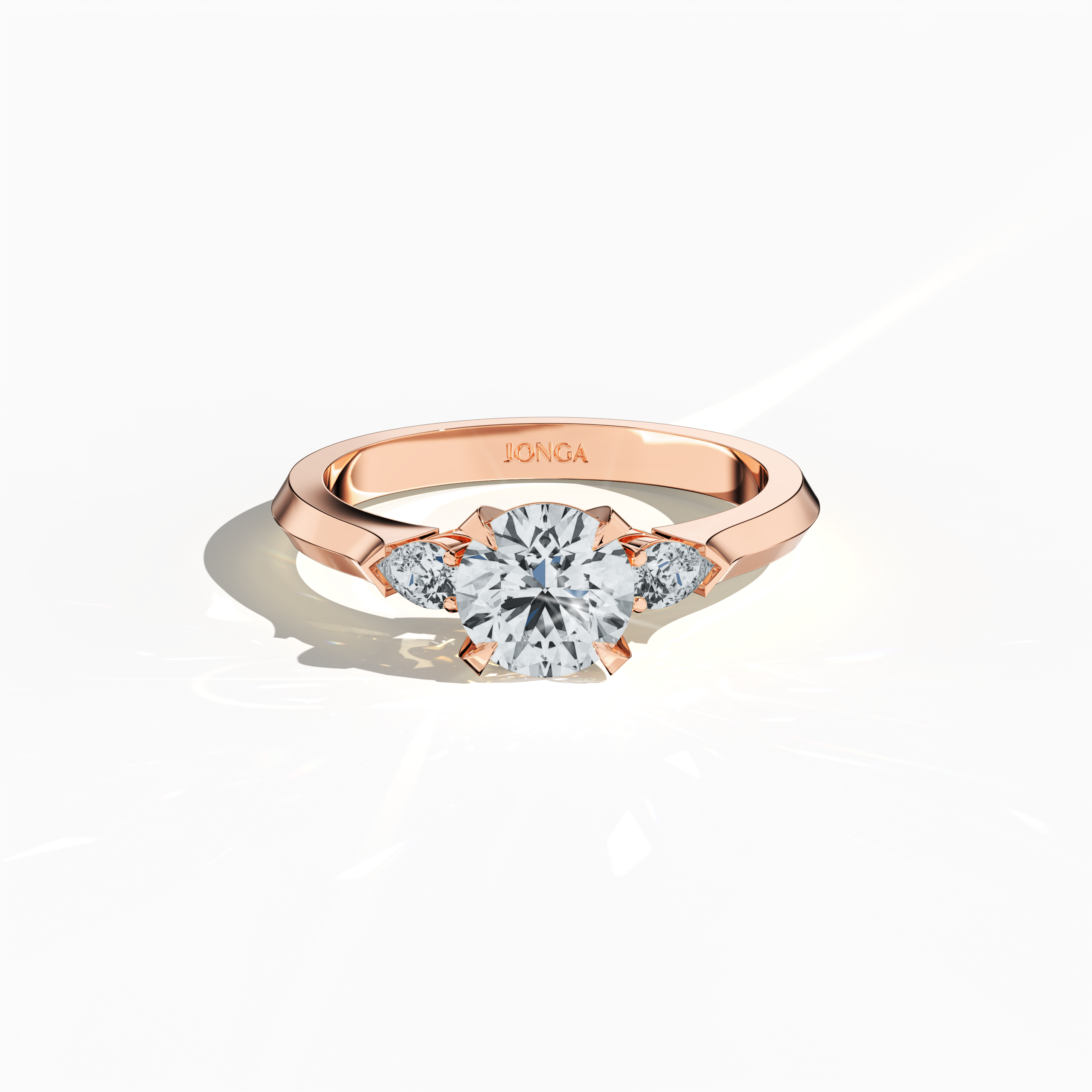 Sleeping front top view of a rose gold trio diamond ring showcasing 1.30 ct natural diamonds—a 1 ct round center/centre diamond with two pear‐shaped side diamonds (0.30 ct total) in a slim band with a four‐nail prong setting. The image highlights its refined craftsmanship and warm glow, ideal as an engagement ring, wedding band, or fine jewelry/fine jewellery piece. Also known as a trilogy ring, three‐stone ring, three‐diamond ring, trinity ring, and triptych ring design. Keywords: rose gold.