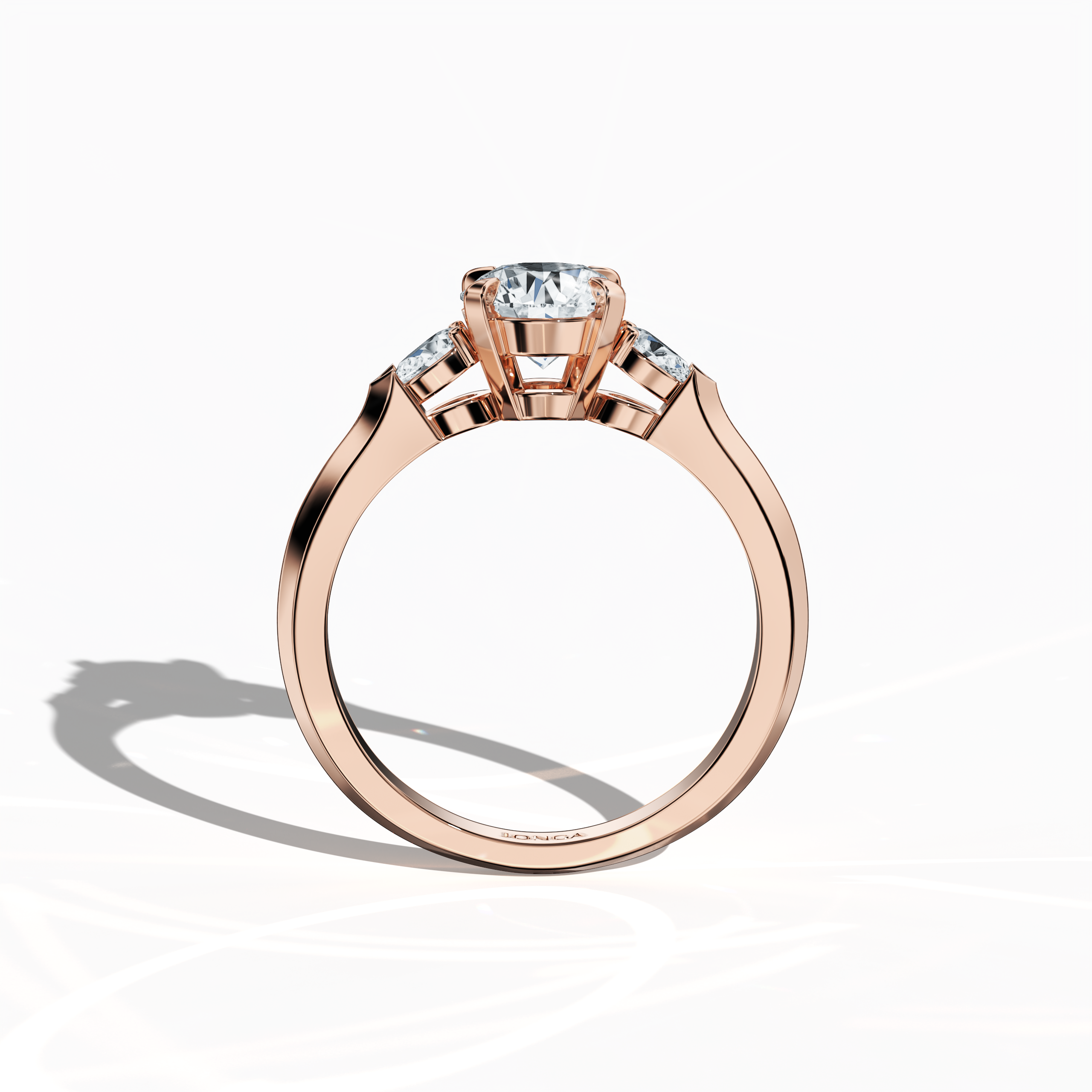 Standing front view of a rose gold trio diamond ring featuring 1.30 ct natural diamonds with a 1 ct round center/centre diamond and two pear‐shaped side diamonds (0.30 ct total) set in a slim band with a four‐nail prong design. Its modern design and warm blush tone make it ideal as an engagement ring, wedding band, or fine jewelry/fine jewellery piece. Also known as a trilogy ring, three‐stone ring, three‐diamond ring, trinity ring, and triptych ring design. Keywords: rose gold, trio diamond ring, modern.