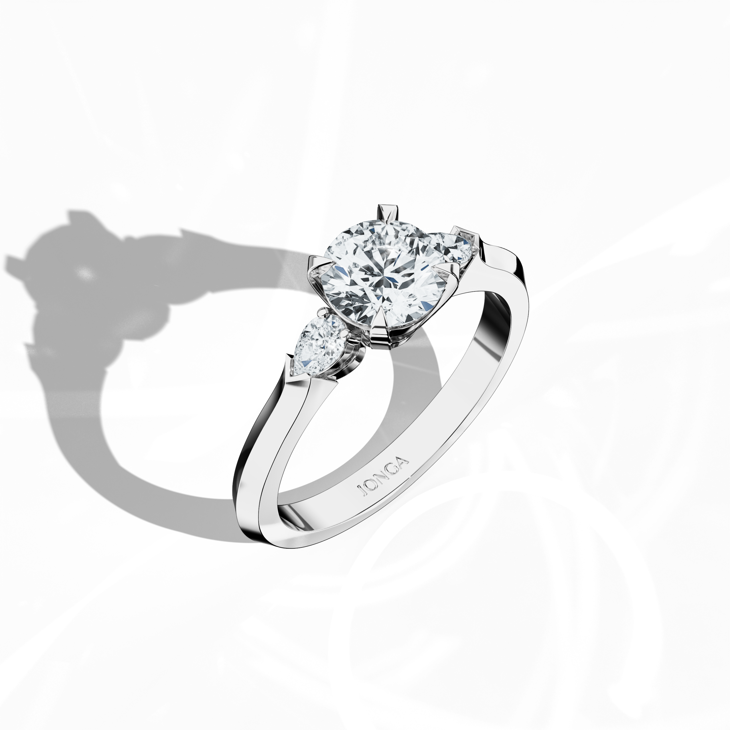 Front top side view of a white gold trio diamond ring featuring a brilliant 1 ct round center/centre diamond with two delicately set pear‐shaped side diamonds (0.30 ct total) in an elegantly slim band with a four‐nail prong design. This dynamic angle reveals intricate detailing and a blend of classic and modern style, ideal as an engagement ring, wedding band, or fine jewelry/fine jewellery piece. Also known as a trilogy ring, three‐stone ring, three‐diamond ring, trinity ring, and triptych ring design.