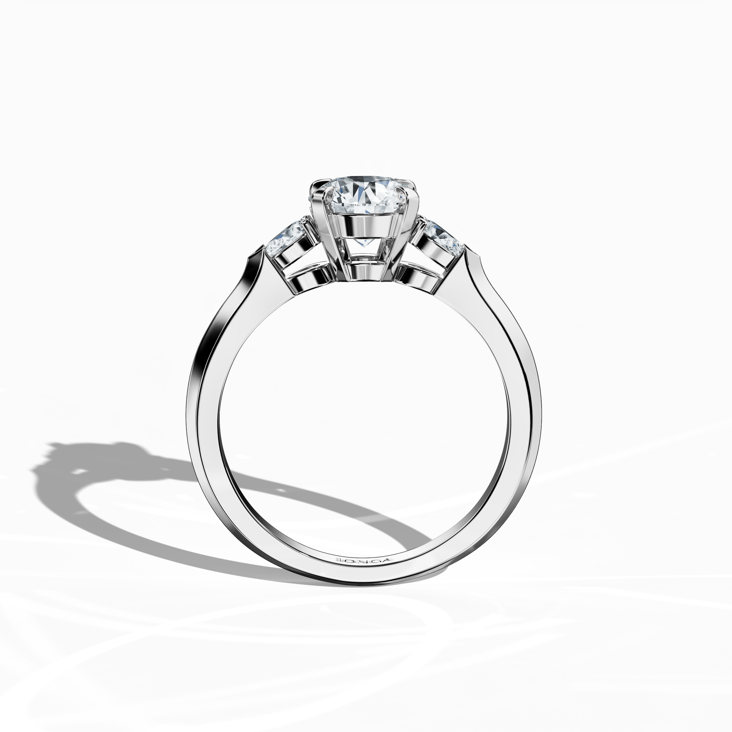 Standing front view of a white gold trio diamond ring, showcasing a dazzling 1 ct round center/centre diamond accented by two pear‐shaped side diamonds (0.30 ct total) in a sleek slim band with a four‐nail prong setting. This perspective highlights its brilliant fire and modern design, making it a stunning engagement ring, wedding band, or fine jewelry/fine jewellery statement piece. Also known as a trilogy ring, three‐stone ring, three‐diamond ring, trinity ring, and triptych ring design.