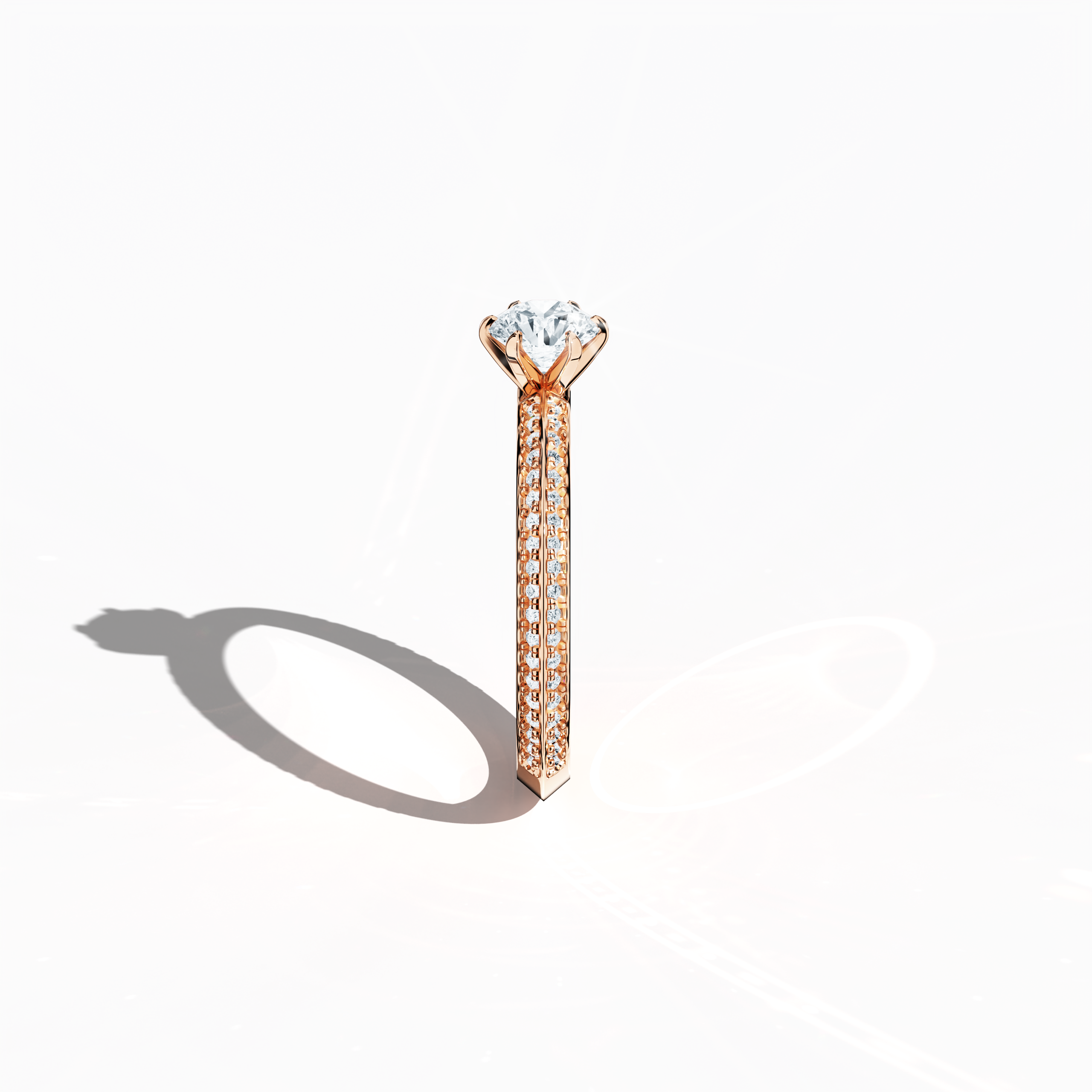 Refined solitaire paved ring with 0.90 ct of diamonds, featuring a 0.50 ct center stone and 0.40 ct pavé side stones, set in soft rose gold (blush/pink gold) with a two‑step band design marked by a sharp central line. Photographed from a standing side view, this fine jewelry/fine jewellery ring showcases its elegant contours and warm, romantic allure.