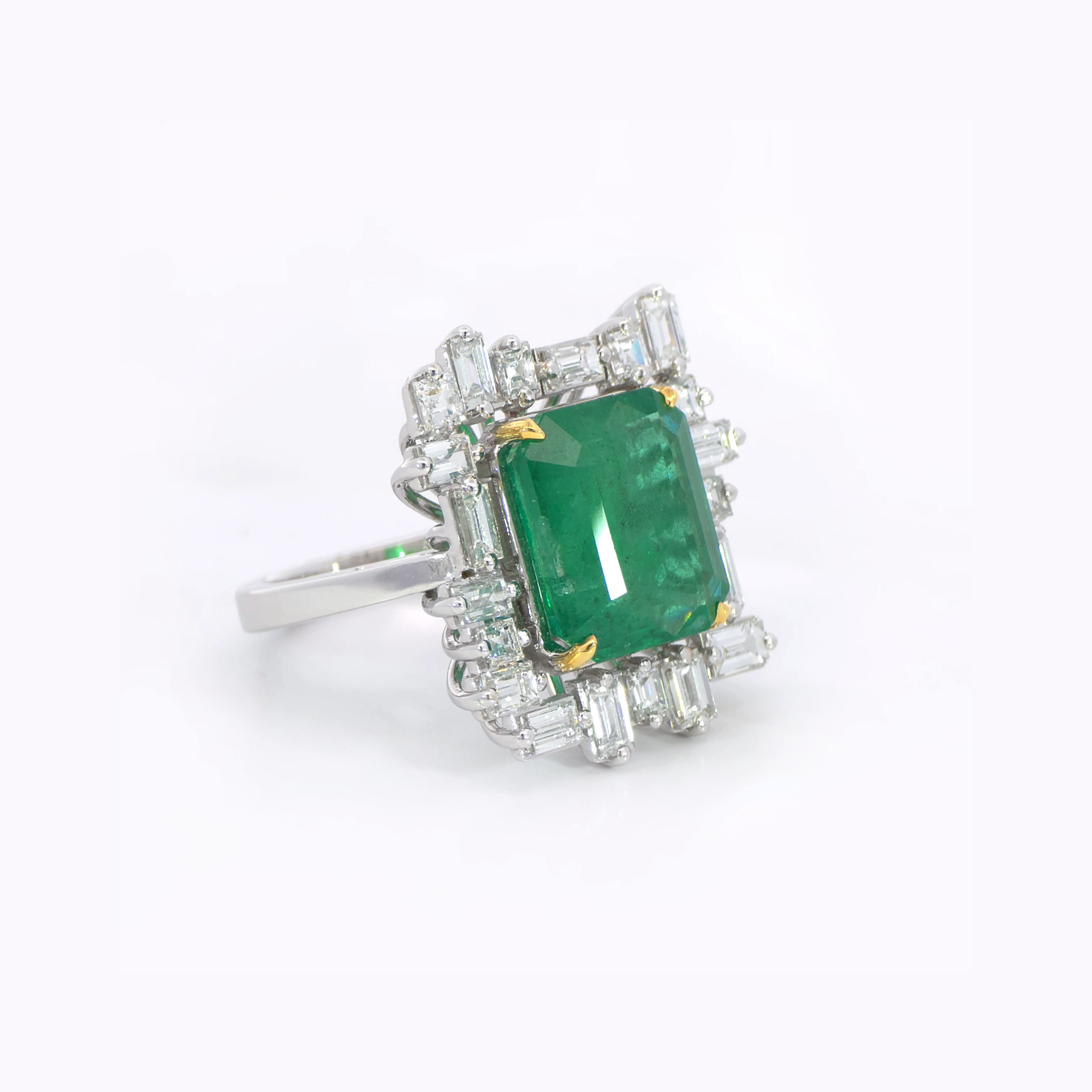 Green Emerald ring side view showing 6.32 carat natural Zambian emerald with tapered baguette diamond halo 18K white gold

